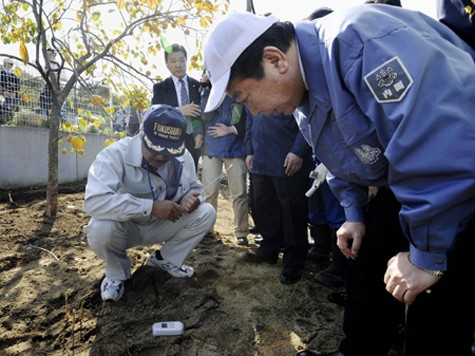 Thủ tướng Nhật Bản Yoshihiko Noda (phải) theo dõi mức phóng xạ đo tại một ngôi nhà ở quận Fukushima, tháng 10/2011.